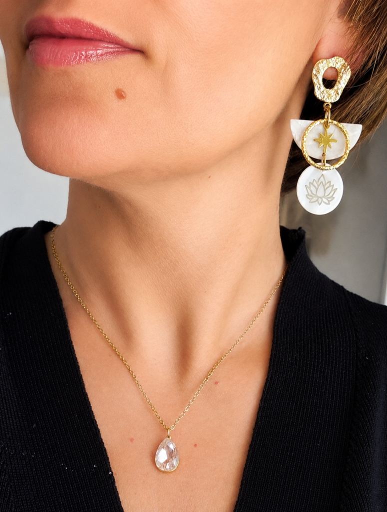Un modèle chic et féminin, pendentifs nacrés et détails symboliques pour un rendu à la fois tendance et intemporel.